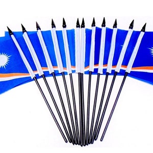 May include: A collection of small flags, each featuring the design of the Marshall Islands flag. The flags are primarily blue with a white star, an orange stripe, and a white stripe. The flags are mounted on black poles.