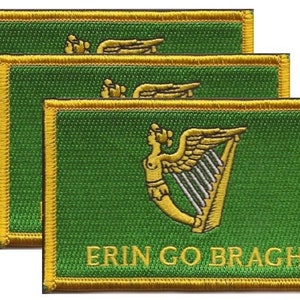 May include: Three green embroidered patches with a gold border. Each patch features a gold harp and the text "ERIN GO BRAGH". The patches are rectangular and have a textured appearance, suggesting they are made of fabric.
