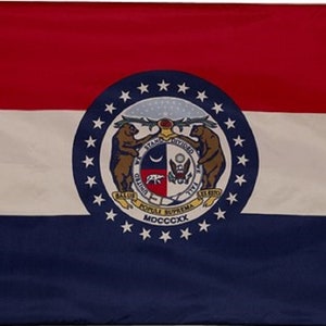 May include: A rectangular flag with horizontal stripes of red, white, and blue. The center features a circular emblem with two brown bears, stars, and text. The flag represents the state of Missouri.