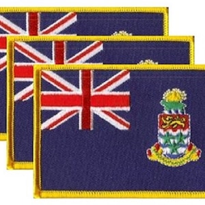 May include: Three embroidered patches featuring the flag of the Cayman Islands. Each patch has a blue background with the Union Jack in the upper left corner and the Cayman Islands coat of arms on the right. The patches are rectangular with a gold border.