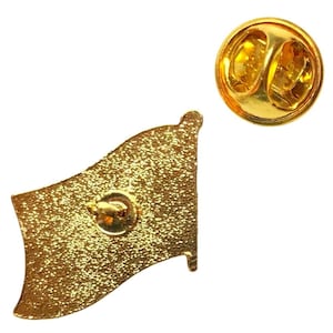 Puede incluir: Un pin de solapa de metal dorado con forma de bandera ondeante y superficie texturizada brillante. El pin cuenta con un poste central en la parte posterior e incluye un cierre de embrague circular de metal dorado para una fijaci&oacute;n segura.
