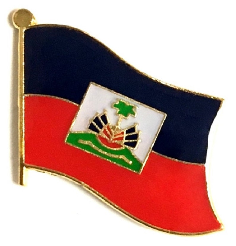 May include: A pin featuring the flag of Haiti. The pin has a gold border and depicts the flag with a blue upper section, a red lower section, and a white square in the center with a coat of arms.