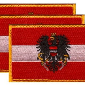 May include: Three embroidered patches featuring the flag of Austria. Each patch has a red background with a white horizontal stripe and a gold border. The Austrian coat of arms, a black eagle with a red and white shield, is centered on the right side.