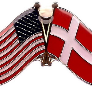 K&ouml;nnte beinhalten: Eine Anstecknadel mit den Flaggen der Vereinigten Staaten und D&auml;nemarks. Die amerikanische Flagge ist rot, wei&szlig; und blau mit Sternen und Streifen. Die d&auml;nische Flagge ist wei&szlig; auf rotem Grund. Die Flaggen sind nebeneinander.