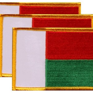 May include: Four embroidered patches featuring the flag of Madagascar. Each patch has a white vertical stripe on the left, a red horizontal stripe in the center, and a green horizontal stripe at the bottom. The patches are rectangular with gold trim.