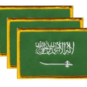 May include: Three embroidered patches featuring the flag of Saudi Arabia. Each patch has a green background with white Arabic script and a white sword. The edges are trimmed with gold thread.