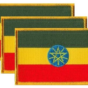 May include: Three embroidered patches featuring the flag of Ethiopia. Each rectangular patch has a green stripe at the top, a yellow stripe in the middle, and a red stripe at the bottom. A blue circle with a yellow star is in the center.