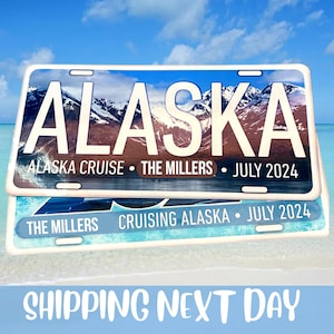 Peut inclure: Deux plaques d'immatriculation sur le th&egrave;me de l'Alaska. La plaque sup&eacute;rieure indique "ALASKA" avec une toile de fond de cha&icirc;ne de montagnes, "ALASKA CRUISE &bull; THE MILLERS &bull; JULY 2024". La plaque inf&eacute;rieure indique "THE MILLERS CRUISING ALASKA &bull; JULY 2024". Le fond est une sc&egrave;ne de plage.
