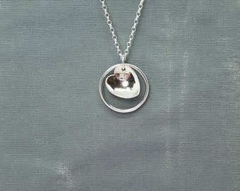 Silver circle of life pendant with a heart accent pendant