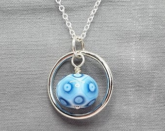 Silver circle of life pendant with a beautiful blue harlequin glass bead