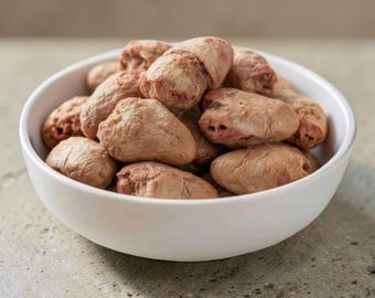 Puede incluir: Un cuenco blanco lleno de un montón de corazones de pollo crudos de color marrón rosáceo. Los corazones tienen un aspecto carnoso y texturizado con fibras musculares visibles y tonos marrón rojizos, apilados en un plato de cerámica.