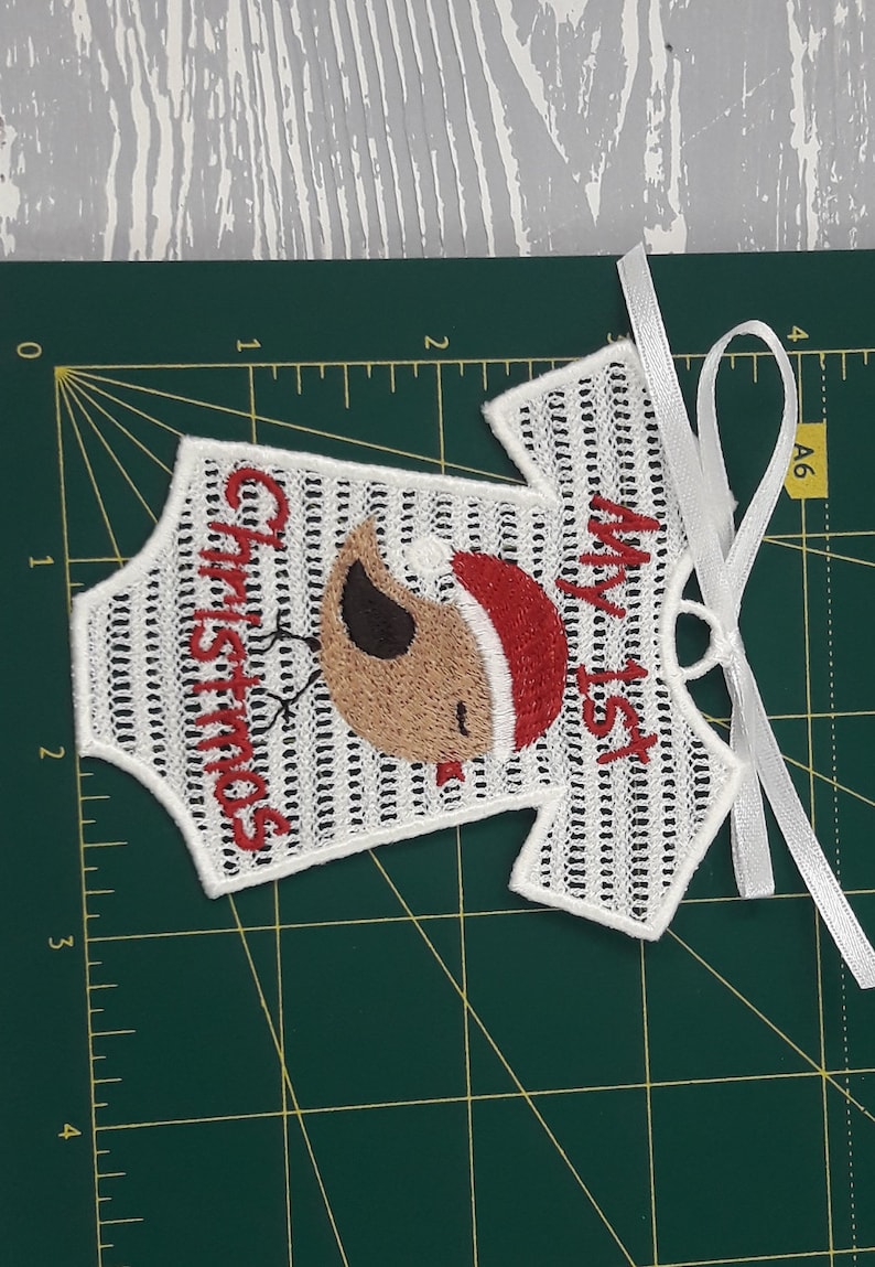 Pu&ograve; includere: Tutina da neonato bianca ricamata con un uccello rosso che indossa un cappello di Babbo Natale e il testo "Il mio primo Natale".