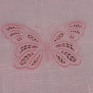 Könnte beinhalten: Ein rosa Schmetterlingsmuster, das auf einen rosa Leinenstoff gestickt ist.