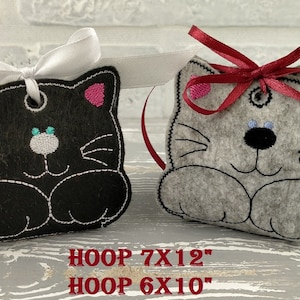 May include: Two felt cat ornaments, one black and one gray, with pink ears and black embroidered features. The black cat is tied with a white ribbon and the gray cat is tied with a red ribbon. The text "HOOP 7X12" and "HOOP 6X10" is printed below the ornaments.