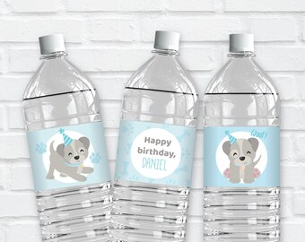 May include: Three clear plastic water bottles with blue and white labels featuring a cartoon dog wearing a party hat. The labels say "Happy birthday, Daniel", "Woof!" and a paw print.