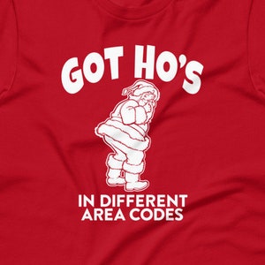 May include: Red t-shirt with a white graphic of Santa Claus and the text "GOT HO'S IN DIFFERENT AREA CODES".