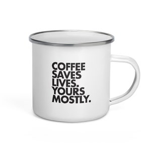 Op de afbeelding: Witte emaille mok met een zwarte inscriptie die "Coffee Saves Lives. Yours Mostly." luidt.
