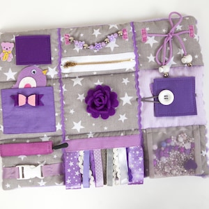 Violet handmade cotton sensory blanket. Size 30x40cm (12x15 in) is very comfortable to use on the knees. Quite fluffy and very soft. On the front part of the mat there are different fidget elements: buttons, beads, ribbons, felt decorations, ties etc