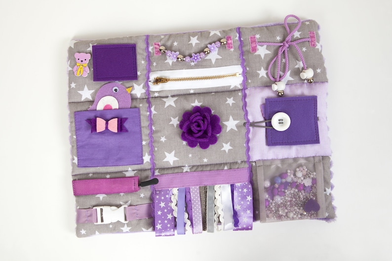 Violet handmade cotton sensory blanket. Size 30x40cm (12x15 in) is very comfortable to use on the knees. Quite fluffy and very soft. On the front part of the mat there are different fidget elements: buttons, beads, ribbons, felt decorations, ties etc