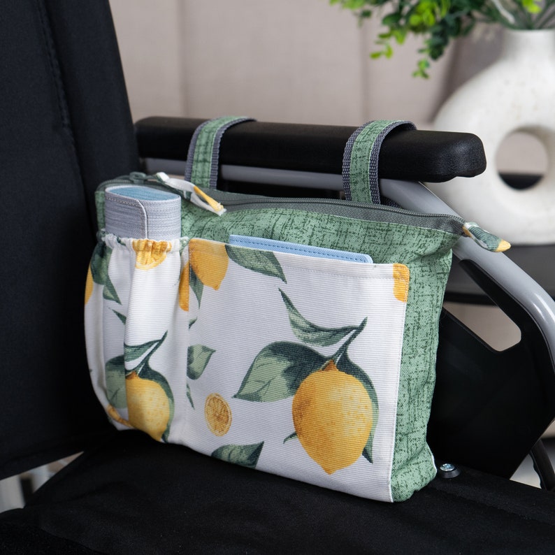 May include: A white and green zippered pouch with a lemon print. The pouch has multiple pockets and is hanging on the armrest of a wheelchair.
Wheelchair Armrest Bag, Walker Side Bag with Zippered Top, Small Walker Bag, Rollator Pouch, Powerchair Organizer, Wheel chair Accessories