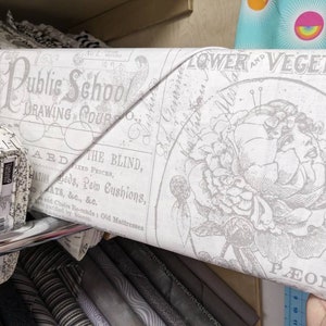 May include: A roll of white fabric with a gray floral print and text that reads "Flower and Vegetable Peony" and "Public School Drawing Course".