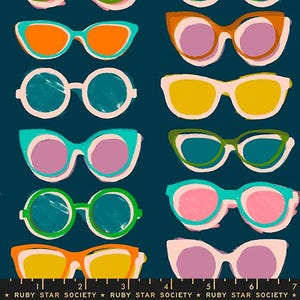 May include: A dark teal fabric featuring a repeating pattern of various sunglasses in shades of orange, pink, yellow, green, and turquoise. A black measuring tape with the text RUBY STAR SOCIETY is visible along the bottom edge of the fabric.