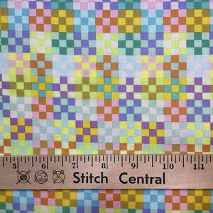May include: Colorful fabric with a repeating checkered pattern in shades of yellow, green, blue, orange, and purple. A wooden ruler with the text "Stitch Central" is at the bottom, measuring in inches.