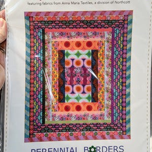 May include: A packaged quilt pattern titled "Perennial Borders" by Anna Maria Patterns. The design features a colorful, rectangular patchwork with floral and geometric patterns. The dimensions are 76" x 92".