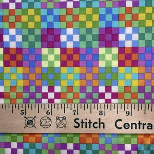 May include: Colorful fabric with a checkerboard pattern in shades of green, blue, purple, orange, and yellow. A wooden ruler with the text "Stitch Central" is at the bottom of the image.