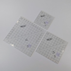 May include: Three clear acrylic quilting rulers with black grid markings and diagonal lines. Each ruler features the Bloc Loc logo and text including On Point, with measurements in inches printed on the surface for precise fabric cutting and alignment.