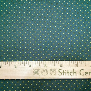 May include: Dark teal fabric with a repeating pattern of small yellow dots. A wooden ruler with inch markings and the text "Stitch Central" is placed across the fabric. The ruler measures up to 9 inches.