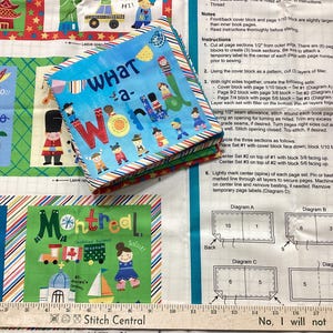 May include: A colorful fabric panel with the words "WHAT a- WORLD" on a small book. The panel features illustrations of various countries and the word "Montreal". A ruler is at the bottom, and instructions are on the right.