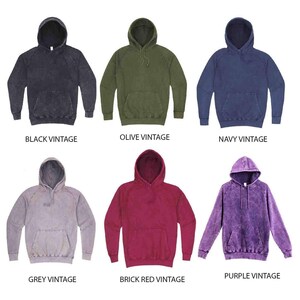 May include: Six different color vintage hoodies. The hoodies are in black, olive, navy, grey, brick red, and purple. Each hoodie has a drawstring hood and a kangaroo pocket.