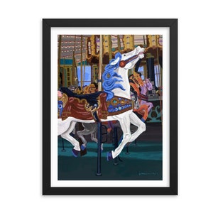 May include: Framed art print of a carousel horse with a white body, blue mane, and decorative saddle. The artwork is set against a backdrop of a carousel with other horses and a blue sky. The print is in a black frame.