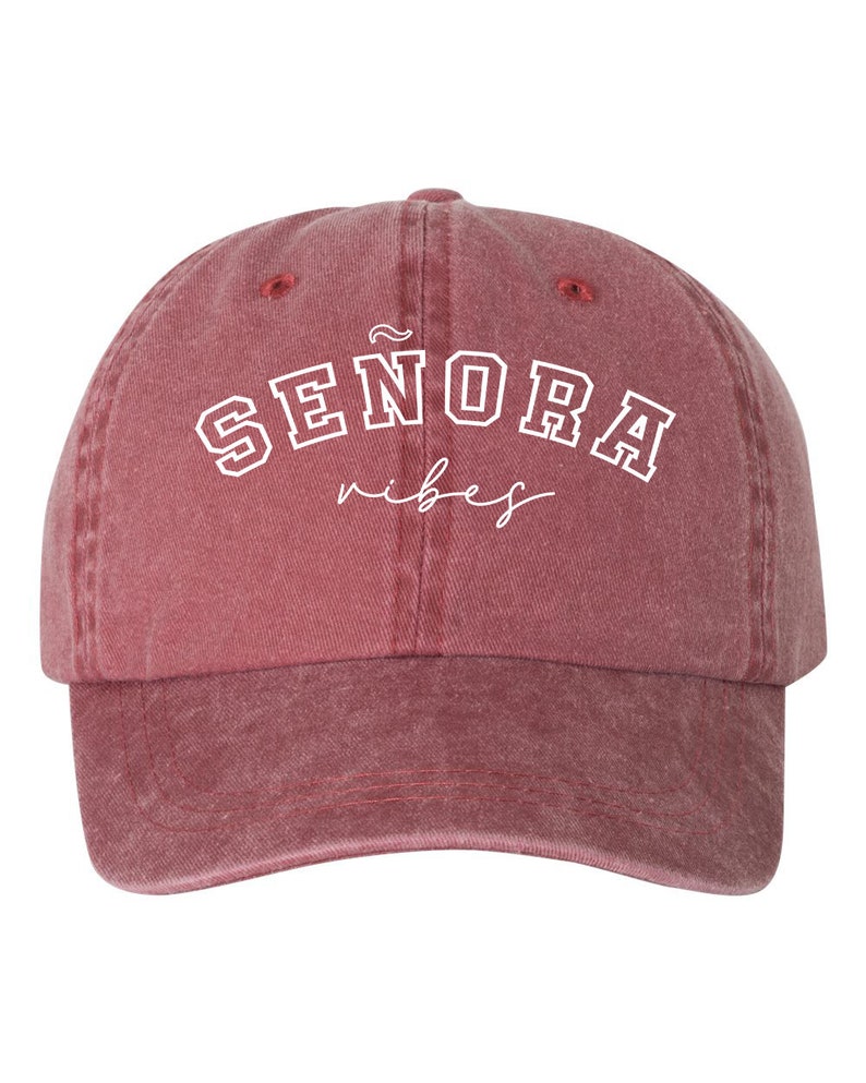 Op de afbeelding: Een rode baseballcap in vintage stijl met witte geborduurde tekst die "SENORA vibes" luidt.