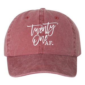 May include: A maroon baseball cap with the text "twenty one AF" in white cursive lettering.