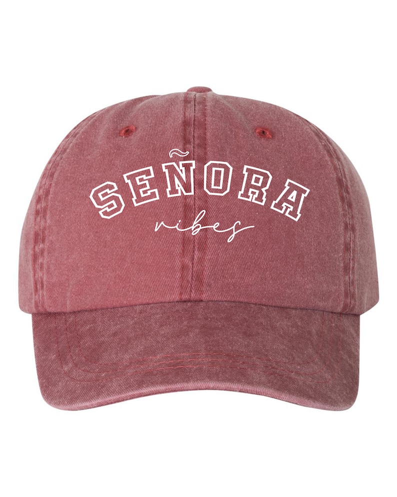 Op de afbeelding: Een rode baseballcap in vintage stijl met witte geborduurde tekst die "SENORA vibes" luidt.