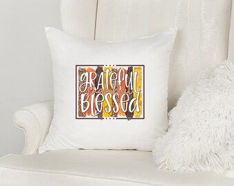 May include: White throw pillow with the text "Grateful Thankful Blessed" in a brown rectangle with a fall-themed design.