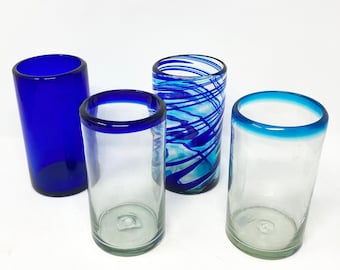 May include: Four glass drinking glasses, two with blue rims, one with a blue and white swirl design, and one solid blue.