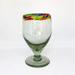 May include: A clear glass goblet with a colorful rim. The rim features a swirl of yellow, orange, blue, and green. The base and stem of the glass are a smoky gray color. The glass is on a white background.