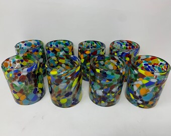 May include: Set of eight colorful glass tumblers with a mosaic design. Each tumbler features a unique pattern of small, colorful glass pieces.