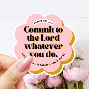 May include: Pink and gold sticker with the text "Commit to the Lord whatever you do, and He will establish your plans."  The text is from Proverbs 16:3.