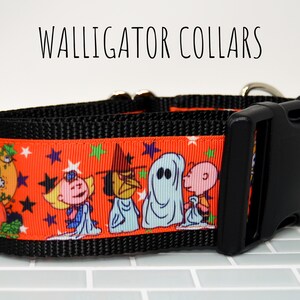 Puede incluir: Un collar de perro negro y naranja con un estampado de Peanuts de tem&aacute;tica de Halloween con Snoopy, Lucy, Linus y Sally. El collar tiene una hebilla negra y un anillo en D plateado.