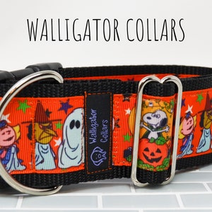 Puede incluir: Un collar de perro negro y naranja con un estampado de Halloween con personajes de la tira c&oacute;mica Peanuts. El collar tiene un anillo en D plateado y una hebilla plateada. El texto "Walligator Collars" est&aacute; impreso en una etiqueta negra unida al collar.