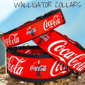 May include: Three red and black dog collars with a Coca-Cola design. The collars feature the Coca-Cola logo and a bottle of Coca-Cola.