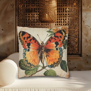May include: A decorative throw pillow with a vintage illustration of an orange and black butterfly with green leaves on a white background.