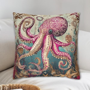 Könnte beinhalten: Ein dekoratives Kissen mit einem rosa und goldenen Oktopus mit komplizierten Mustern auf einem blaugrünen Hintergrund. Der Oktopus hat acht Tentakel und ist von Seegras und anderen Meereslebewesen umgeben.