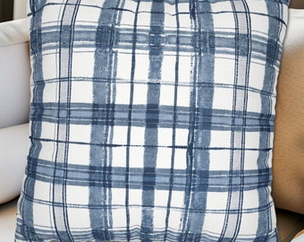 May include: Square throw pillow with a blue and white plaid pattern. The pillow features a classic grid design with varying shades of blue, creating a textured, brushstroke effect. The pillow is a decorative accent for a sofa or bed.