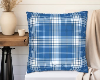 May include: Square throw pillow with a blue and white plaid pattern. The pillow has a classic grid design with alternating stripes of blue and white. The pillow is placed on a white surface.