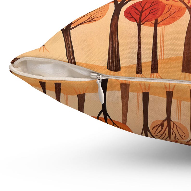 May include: A throw pillow with a zipper closure features a repeating pattern of stylized trees with orange, red, and brown leaves against a light orange background.